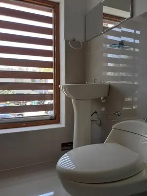 a white bathroom with a toilet and a sink at Adri s House in Lima