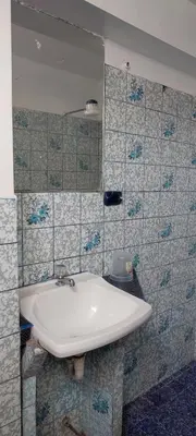 a bathroom with a white sink and blue tiles at Hostal Reyna in Lima