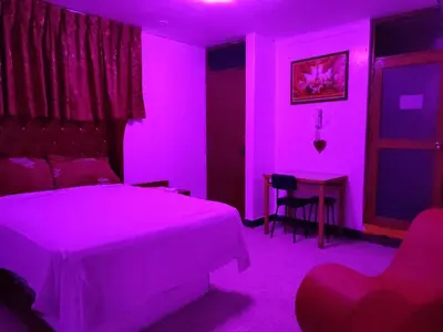 a bedroom with a bed and a table with a purple light at Hostal Reyna in Lima
