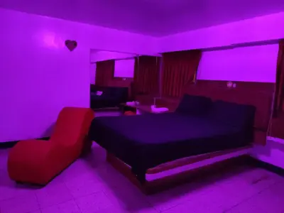 a bedroom with a purple room with a bed and a chair at Hostal Reyna in Lima
