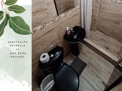 a bathroom with a black toilet and a sink at Casa Vacacional Puro Jita in Lunahuaná
