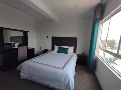 a hotel room with a bed and a large window at Blub Hotel Spa in Huancayo