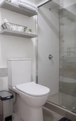 a bathroom with a toilet and a glass shower at Apartamento de estreno en Miraflores Gym/Piscina in Lima