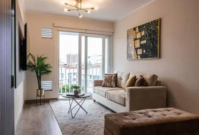a living room with a couch and a large window at Apartamento de estreno en Miraflores Gym/Piscina in Lima