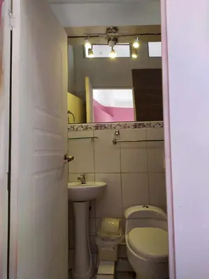 a bathroom with a sink and a toilet and a mirror at Yllari's Inn in Cusco