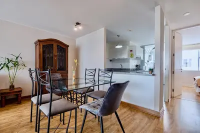 a dining room and kitchen with a glass table and chairs at ALU Apartments - Miraflores Boardwalk, Wifi 70M in Lima