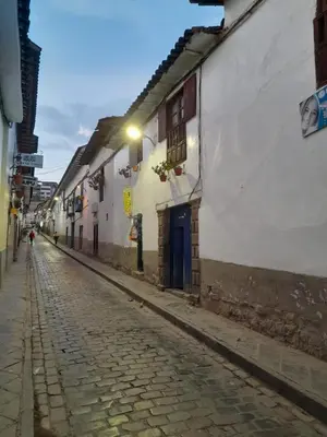 a cobblestone street in an alley with buildings at Washichay in Cusco