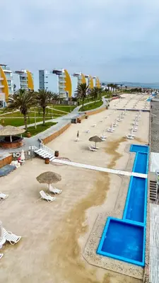 a beach with a bunch of chairs and umbrellas at 1er Piso Vista a Bahía Paracas - Las Velas 102 T1 in Paracas