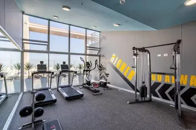 a gym with several treadmills and elliptical machines at Audacity Moderno Departamento in Lima