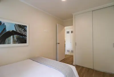 a bedroom with a white bed and a closet at Mirano by Wynwood House in Lima