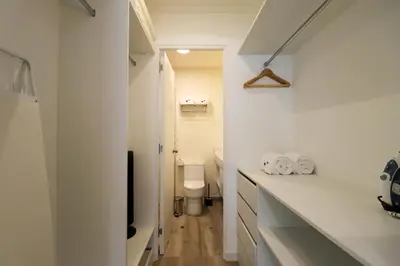 a white bathroom with a toilet and a television at Mirano by Wynwood House in Lima
