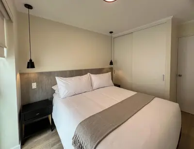 a bedroom with a large white bed with two pillows at Mirano by Wynwood House in Lima