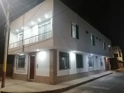 a white building with a balcony on the side of it at Alemar's House in Nazca
