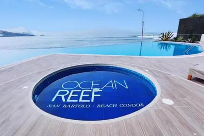 a sign that reads ocean reef next to a swimming pool at Departamento de Playa San Bartolo SOL ARENA & MAR in San Bartolo