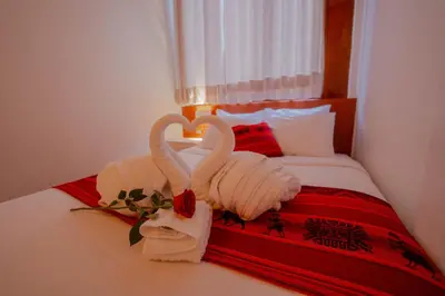 two swans towels and a rose on a bed at DANNA INN in Machu Picchu