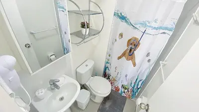 a bathroom with a white toilet and a sink at Depa playa San Bartolo 3 camas piscina wifi juegos in Lima