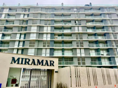 a large apartment building with a sign in front of it at Depa playa San Bartolo 3 camas piscina wifi juegos in Lima