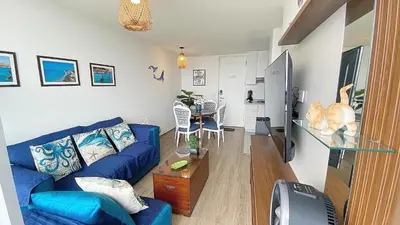 a living room with a blue couch and a glass table at Depa playa San Bartolo 3 camas piscina wifi juegos in Lima