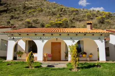 a house with a mountain in the background at Fundo Alma Andina in Jauja