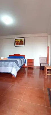 a bedroom with a bed and a chair and a couch at Casa Tejedora in Chinchero