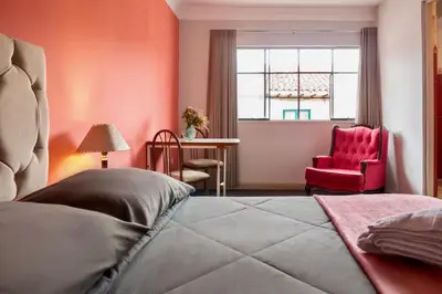 a bedroom with a bed and a red chair at Templo de la Luna in Cusco