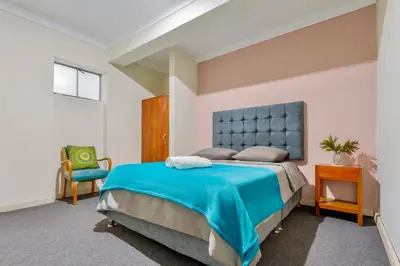 a bedroom with a blue bed and a chair at Templo de la Luna in Cusco