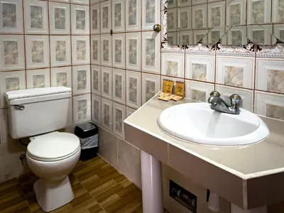 a bathroom with a white toilet and a sink at Santuario Machupicchu in Machu Picchu