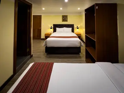 a hotel room with a large bed with white sheets at Santuario Machupicchu in Machu Picchu