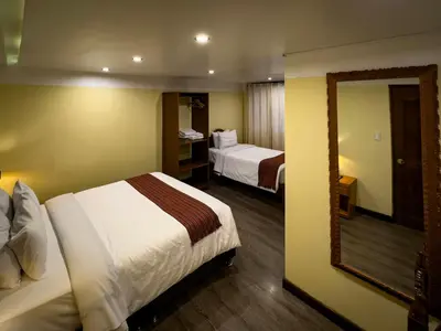 a hotel room with two beds and a mirror at Santuario Machupicchu in Machu Picchu