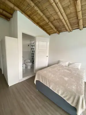a bedroom with a bed and a bathroom with a toilet at Mirador del Paraiso in Lunahuaná