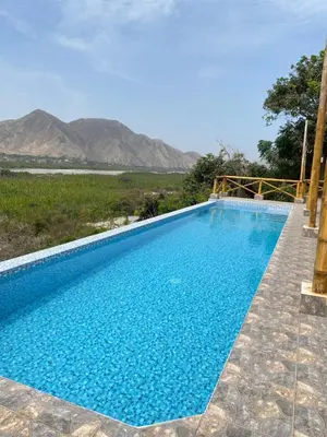 a swimming pool with mountains in the background at Mirador del Paraiso in Lunahuaná