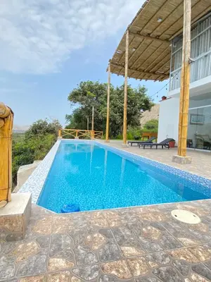 a swimming pool in front of a house at Mirador del Paraiso in Lunahuaná