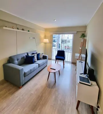 a living room with a couch and a table at Hermoso y céntrico 1BR en Barranco con cochera wifi y netflix in Lima