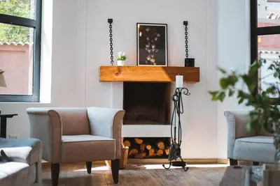 a living room with two chairs and a fireplace at Hermosa casa en Valle Sagrado in Cusco