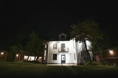 a white house with a balcony at night at Hermosa casa en Valle Sagrado in Cusco