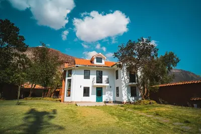 a white house with an orange roof at Hermosa casa en Valle Sagrado in Cusco