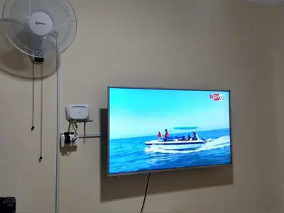 a flat screen tv with people on a boat on the water at LA CASA DE LA ABUELA in Barranca