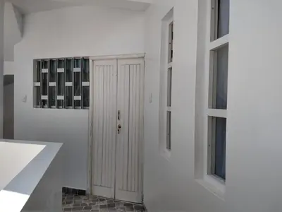 a white hallway with a door and two windows at LA CASA DE LA ABUELA in Barranca