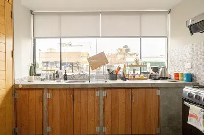 a kitchen with a window and a counter with a sink at Acogedor Loft equipado con Sofá cama en Matellini in Lima