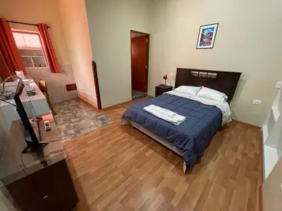 a bedroom with a bed with a blue comforter at Anka Wasi Lodging in Cusco