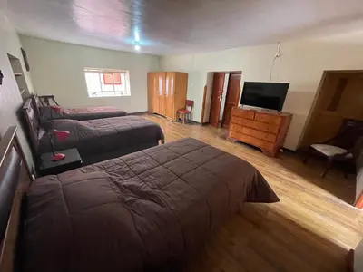 a bedroom with two beds and a flat screen tv at Anka Wasi Lodging in Cusco