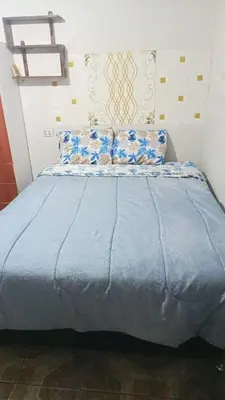 a bed with blue sheets and pillows in a room at POSADA ISABELITA in Lima