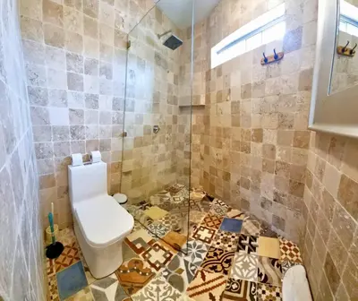 a bathroom with a toilet and a tiled floor at San Isidro Suites Basadre 1B403 in Lima