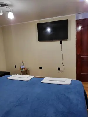 a bedroom with a blue bed with a flat screen tv on the wall at HOME BLESSED II in Lima
