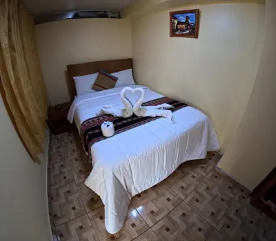 a bedroom with a bed with white towels on it at LA JOYA DE SAN BLAS in Cusco