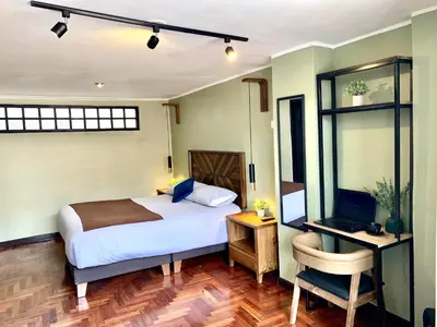 a bedroom with a bed and a desk with a computer at Apartamentos Montes in Cusco