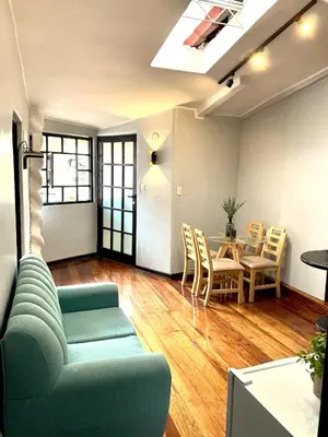 a living room with a couch and a table and chairs at Apartamentos Montes in Cusco
