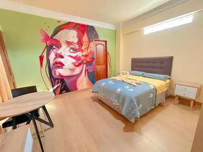 a bedroom with a large painting of a woman at Hotel Retamayo in Ica