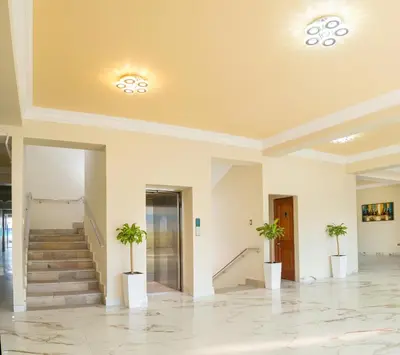 a large lobby with stairs and potted plants at Hotel Retamayo in Ica