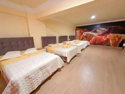 three beds in a room with a painting on the wall at Hotel Retamayo in Ica